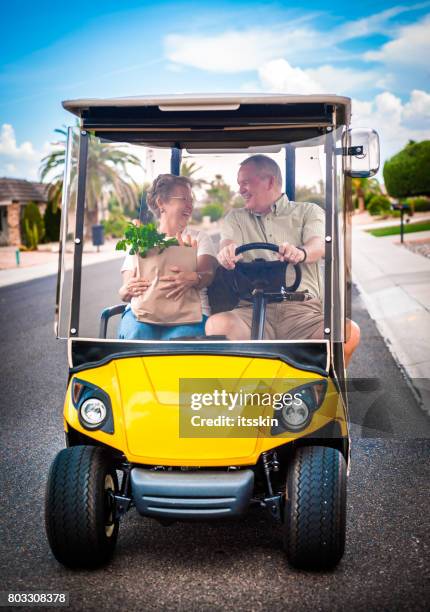 senior couple returning home after shopping - golf cart stock pictures, royalty-free photos & images