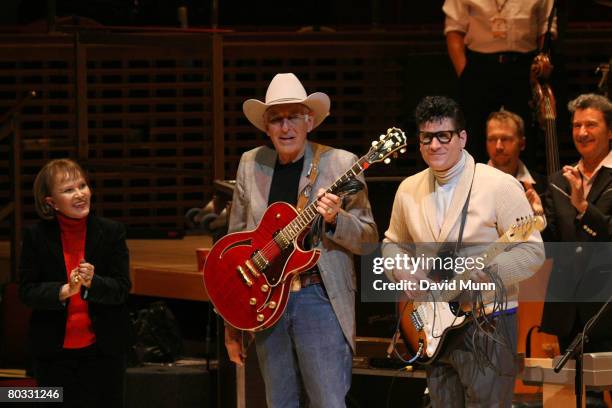 Maria Elena Holly and Tommy Allsup stand on stage at the finale of The 50th Anniversary Buddy Holly Tribute Concert at the Liverpool Philharmonic...