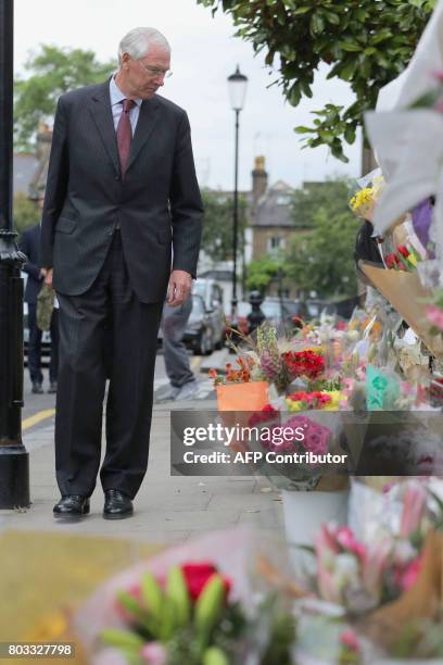 Retired Court of Appeal judge Sir Martin Moore-Bick, who will lead the Grenfell Tower fire public inquiry, looks at flowers left in tribute to the...