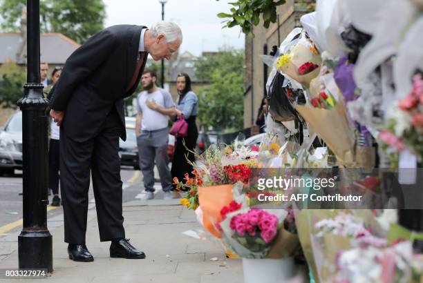 Retired Court of Appeal judge Sir Martin Moore-Bick, who will lead the Grenfell Tower fire public inquiry, looks at flowers left in tribute to the...