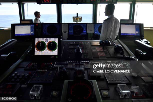 Officers work in the command bridge of the Cunard cruise liner RMS Queen Mary 2 sailing in the Atlantic ocean, on June 28 during The Bridge 2017, a...