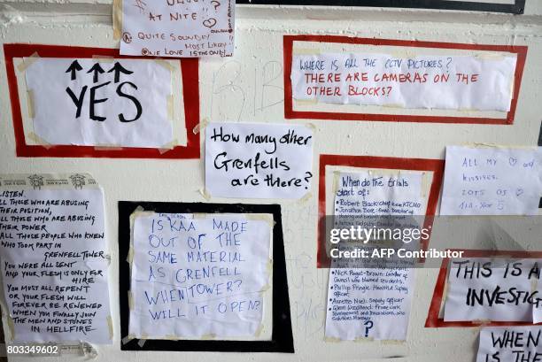 Questions are posted onto a mural in memory of the victims of the Grenfell tower fire painted on a wall under the Westway flyover in London on June...