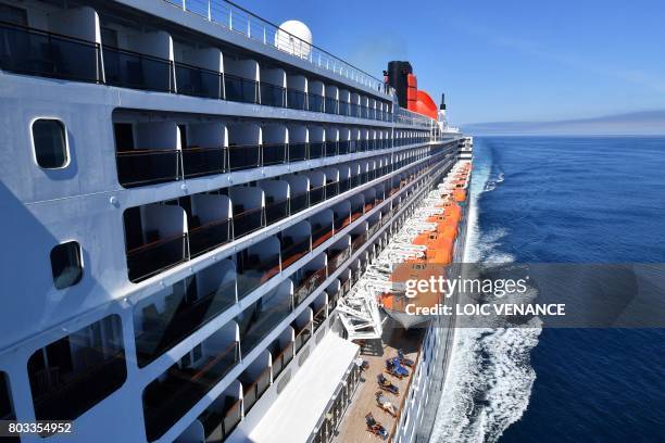 People sunbath aboard of the Cunard cruise liner RMS Queen Mary 2 sailing in the Atlantic ocean, on June 28 during The Bridge 2017, a transatlantic...