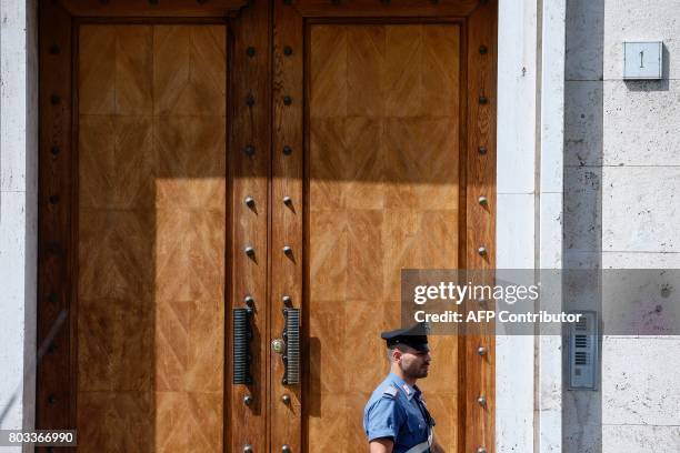 Carabiniere para-military policeman patrols in front of the entrance to the house of Cardinal George Pell at Piazza della Cittadina Leonina in Rome...