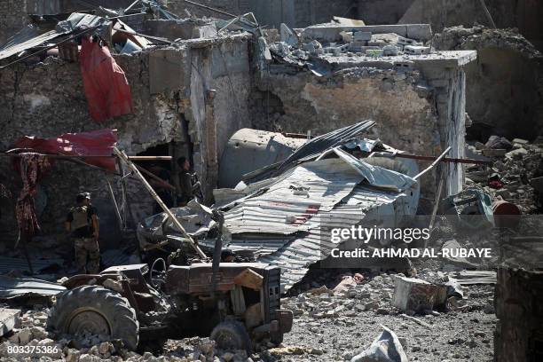 Members of the Iraqi Counter-Terrorism Service advance through the rubble towards the Grand Mosque of Nuri in the Old City of Mosul on June 29 during...