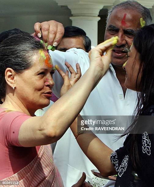 Chairperson of the Congress-led UPA government and Congress Party President Sonia Gandhi is daubed with festive "Holi" colours from party supporters...