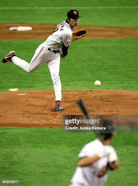 Starting pitcher Koji Uehara of Yomiuri Giants pitch against Mark Ellis of Oakland Athletics during preseason friendly game between Oakland Athletics...