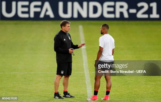 Head coach Stefan Kuntz of Germany talks with team mate Serge Gnabry of Germany during the MD-1 training session of the U21 national team of Germany...