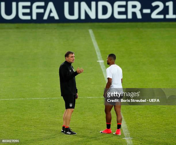 Head coach Stefan Kuntz of Germany talks with team mate Serge Gnabry of Germany during the MD-1 training session of the U21 national team of Germany...