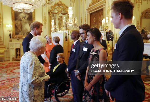 Britain's Queen Elizabeth II and Britain's Prince Harry greet Dame Tanni Grey-Thompson, Mo Farah, Liam Payne, Anita Rani and Caspar Lee during a...