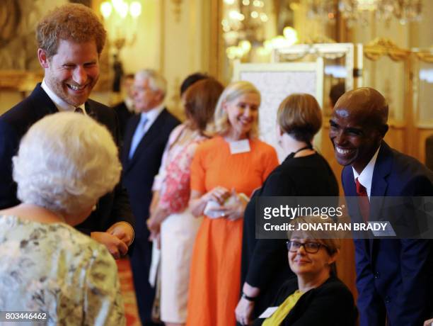 Britain's Queen Elizabeth II and Britain's Prince Harry greet Dame Tanni Grey-Thompson and Sir Mo Farah during a reception prior to the Queen's Young...