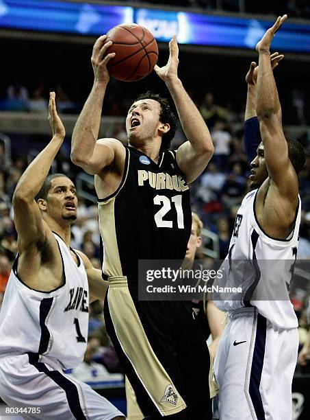 Nemanja Calasan of the Purdue Boilermakers goes to the hoop against Josh Duncan and Stanley Burrell of the Xavier Musketeers during the second round...