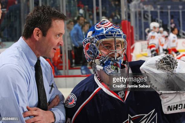 Goaltender Dan LaCosta of the Columbus Blue Jackets talks with Blue Jackets goaltender coach Clint Malarchuk before the start of the game against the...