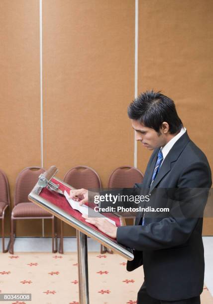 side profile of a businessman giving speech at a lectern - business person handing over a letter fotografías e imágenes de stock