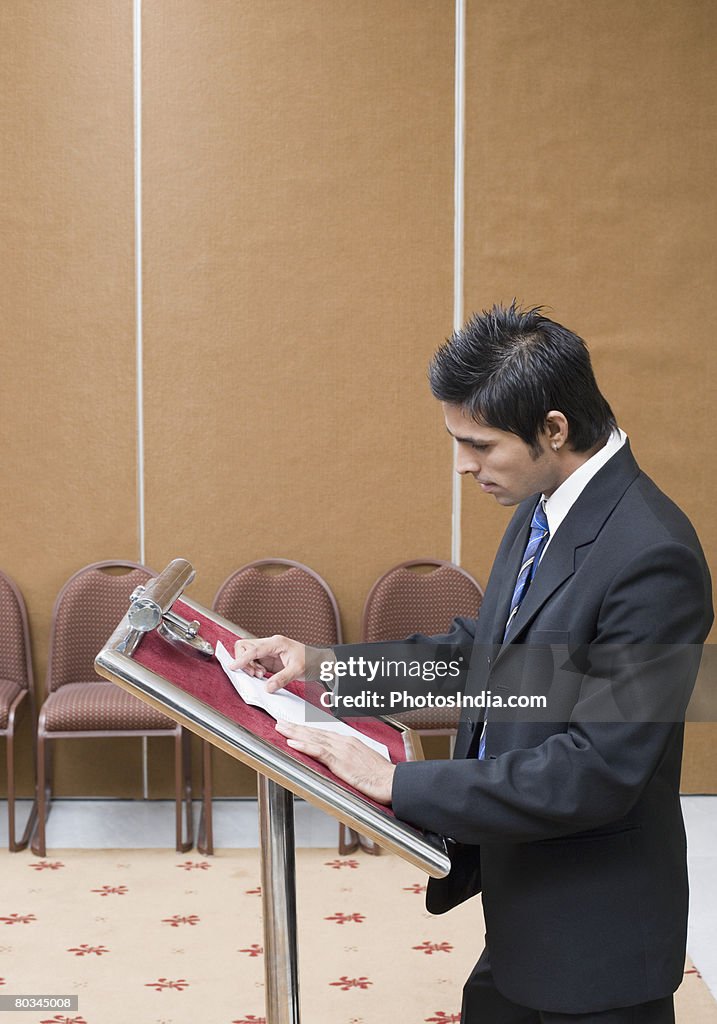 Side profile of a businessman giving speech at a lectern