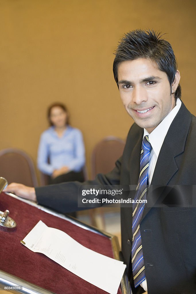 Portrait of a businessman standing at a podium and smiling