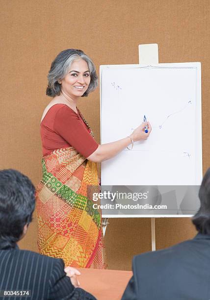 portrait of a businesswoman giving presentation in a meeting and smiling - business person handing over a letter fotografías e imágenes de stock