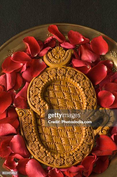 close-up of a ohm symbol with rose petals in a plate - ohm symbol stock-fotos und bilder