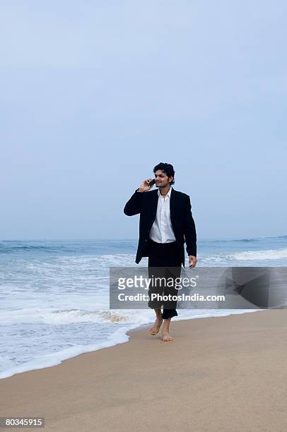 young man talking on a mobile phone - rolled up pants stockfoto's en -beelden