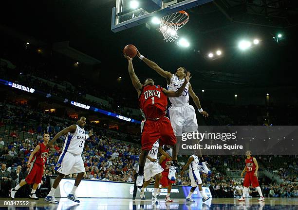 Wink Adams of the UNLV Runnin' Rebels is fouled as he drives for a shot attempt against Brandon Rush of the Kansas Jayhawks during the Midwest Region...