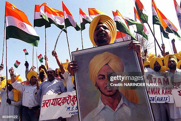Indian members of the All India Anti Terrorism Front wave Indian flags and holds photographs of Indian freedom fighter Shaheed-e-Azam Bhagat Singh,...
