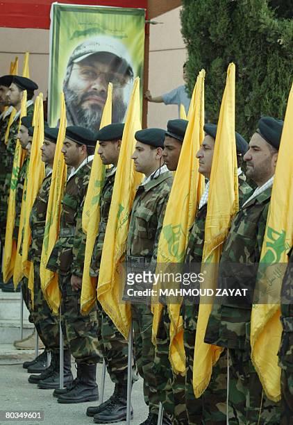 Hezbollah fighters parade with the Shiite militia's yellow flags during a memorial ceremony held for the group's slain commander Imad Mughnieh in the...