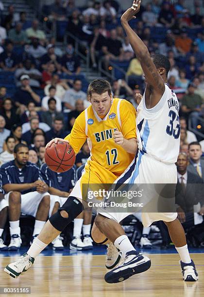 Josh Duell of the Siena Saints drives toward the basket as he is guarded by Dante Cunningham of the Villanova Wildcats in the second round of the...