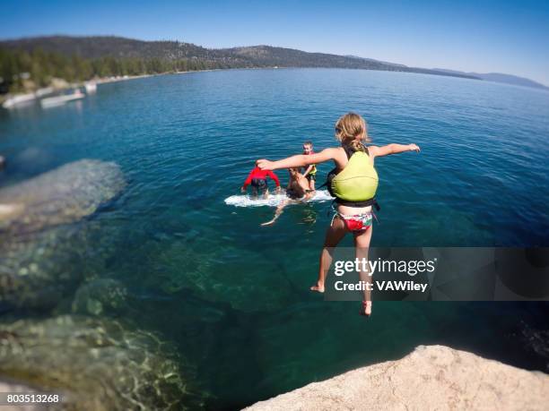 brave girl jumping off rock to dad in the water - 2017 usa diving summer stock pictures, royalty-free photos & images