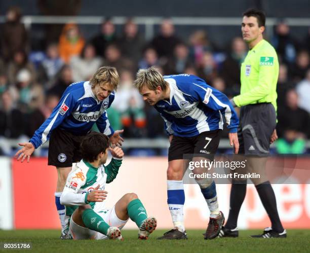 Rudiger Kauf and Thorben Marx of Bielefeld verbally abuse at Diego of Bremen whilst the referee watches during the Bundesliga match between Arminia...
