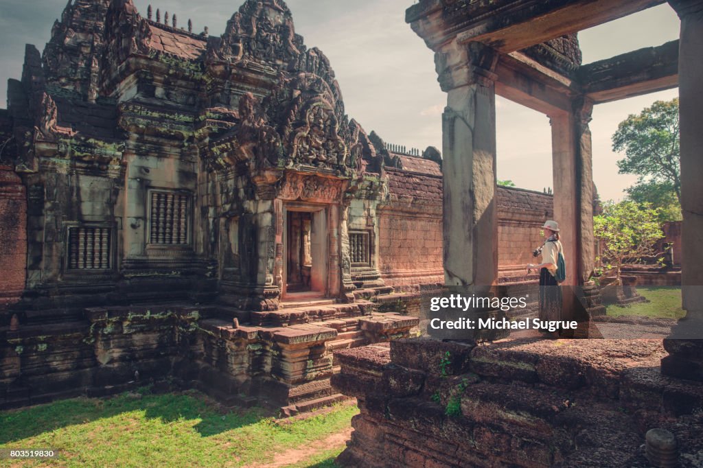 A female tourist photographs Banteay Samre Temple at sunrise, near Angkor Wat, Siem Reap, Cambodia.