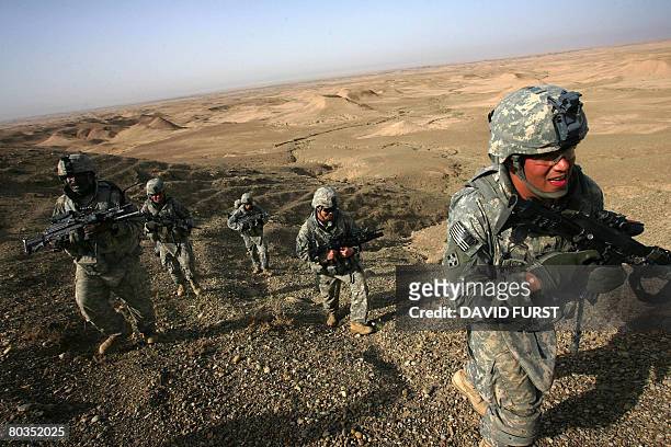 Soldiers from Ghostrider Company 3rd Squadron 2nd Stryker Cavalry Regiment climb a desert ridge as they hunt for caves and tunnels used by insurgents...