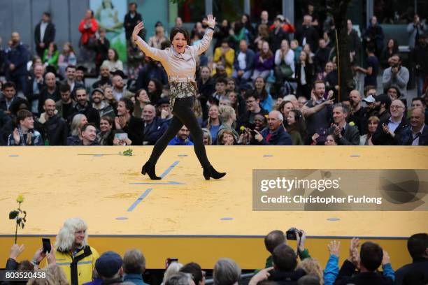 People parade on a 100m long catwalk installed high above the ground as part of What Is The City But The People? show in Piccadilly Gardens on June...