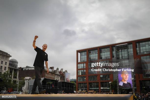 People parade on a 100m long catwalk installed high above the ground as part of What Is The City But The People? show in Piccadilly Gardens on June...