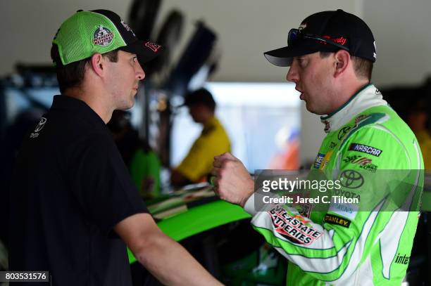 Kyle Busch , driver of the Interstate Batteries Toyota, talks with his interim crew chief Jacob Canter in the garage area during practice for the...