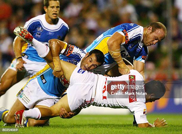 Rangi Chase of the Dragons is tackled by Anthony Laffranchi and Luke Bailey of the Titans during the round two NRL match between the St George...