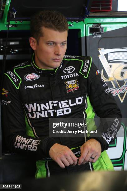 Dakoda Armstrong, driver of the WinField United Toyota, stands in the garage area during practice for the NASCAR XFINITY Series Coca-Cola Firecracker...