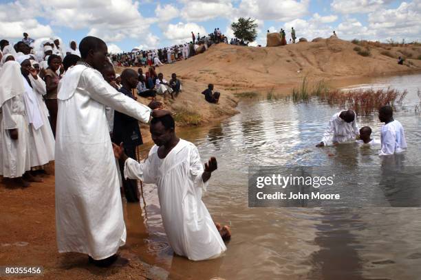 An Evangelical Christian is blessed after being baptized in a pond March 23, 2008 on the outskirts of Bulawayo, Zimbabwe. Leaders of local...