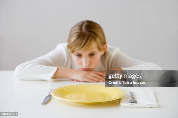 teenaged girl looking at empty plate - girl empty plate stock pictures, royalty-free photos & images