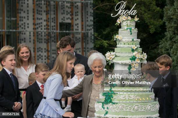 Queen Paola of Belgium invites Crown Princess Elisabeth of Belgium to blow a canddle on her anniversary cake outside the Music Chapel where the Queen...
