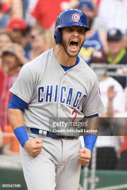 Tommy La Stella of the Chicago Cubs celebrates scoring on a single by Javier Baez during a baseball game against the Washington Nationals at...