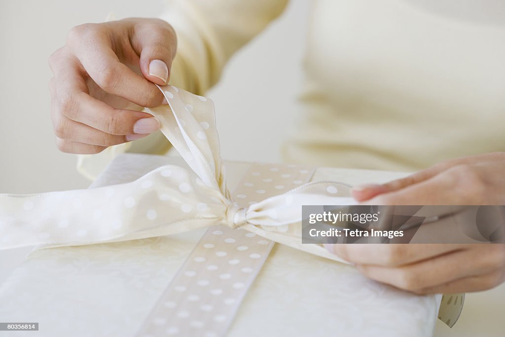 Close up of woman tying gift bow