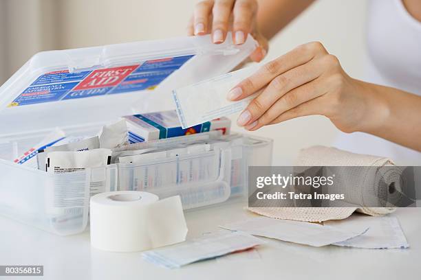 woman packing first aid kit - ehbo doos stockfoto's en -beelden