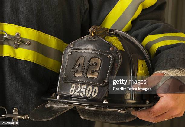 close up of firefighter holding helmet - feuerwehrhelm stock-fotos und bilder
