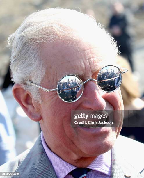 Members of the media are reflected in some snow glasses as Prince Charles, Prince of Wales attends a community feast event at Sylvia Grinnel...