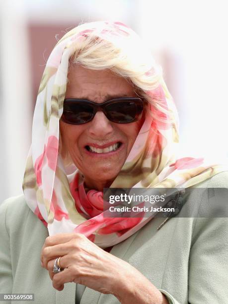 Camilla, Duchess of Cornwall holds on to her headscarf during a gust of wind at an official welcome ceremony at Nunavut Legislative Assembley during...