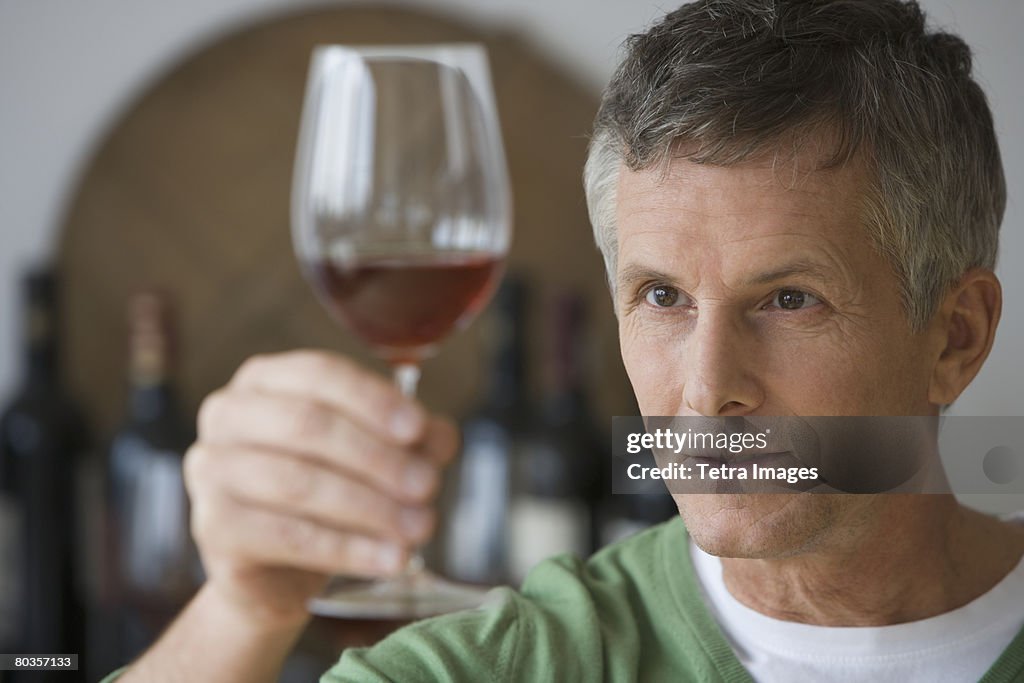 Man looking at glass of wine