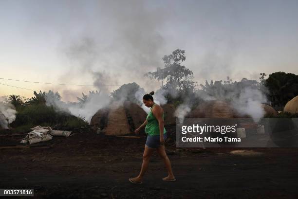 Smoke rises as Amazon wood scraps are burned for charcoal in a deforested section of the Amazon on June 26, 2017 near Ariquemes, Rondonia state,...