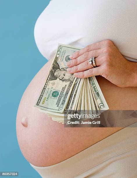pregnant woman holding stack of money - remplacement photos et images de collection