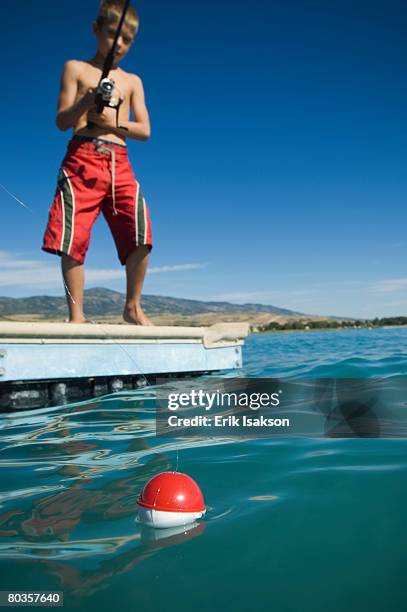 boy fishing off dock in lake, utah, united states - fishing float stock pictures, royalty-free photos & images