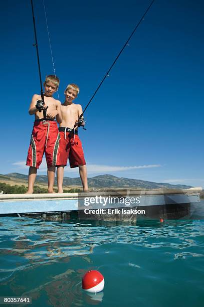 brothers fishing off dock in lake, utah, united states - float stock pictures, royalty-free photos & images